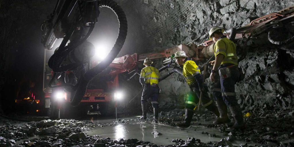Miners working in Byrnecut Jundee Gold Mine project with Sandvik DD041 in the background